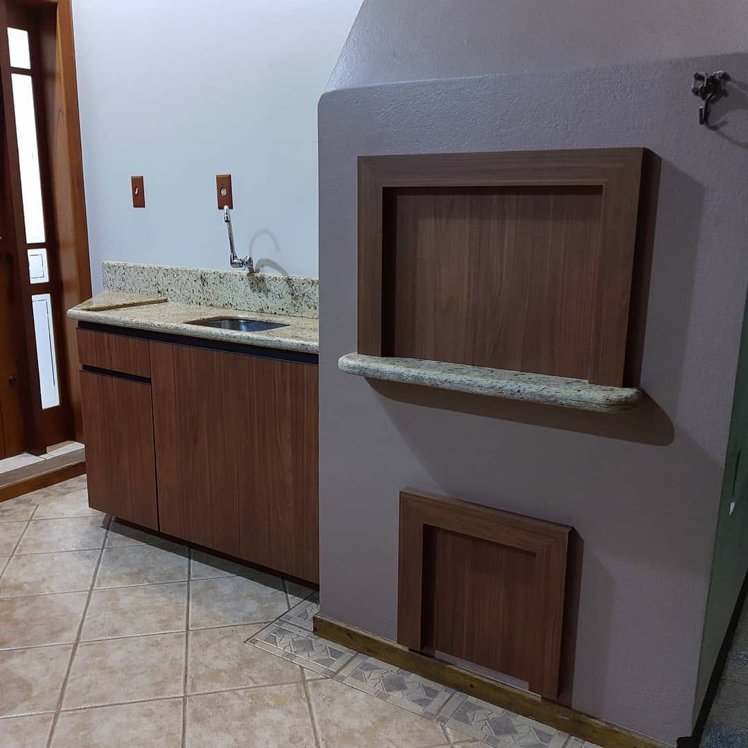 Área gourmet com gabinete e nichos em madeira